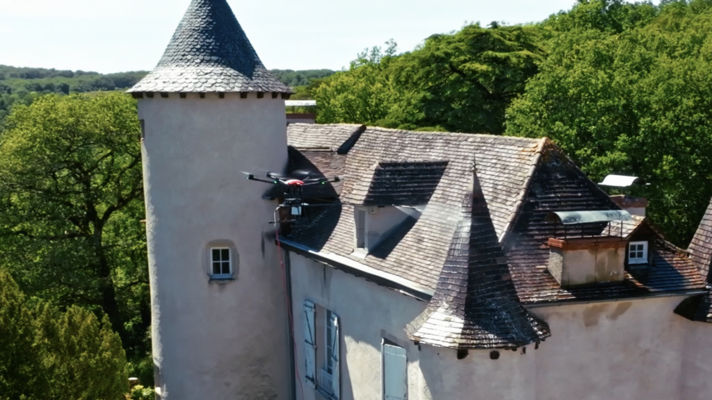 Drone ou nacelle : un drone de nettoyage pulvérise un produit sur une toiture